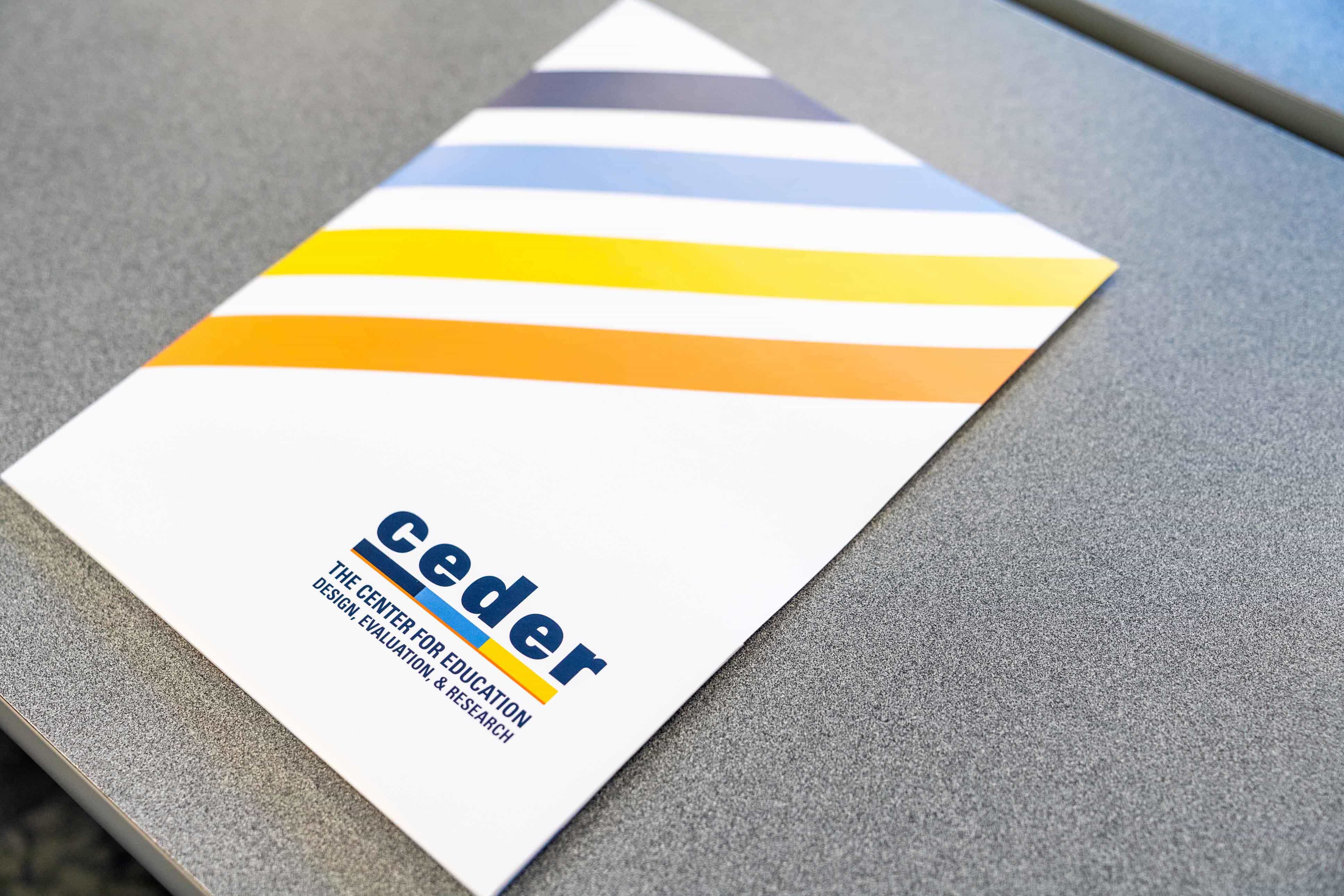 CEDER-branded folder on a grey desk
