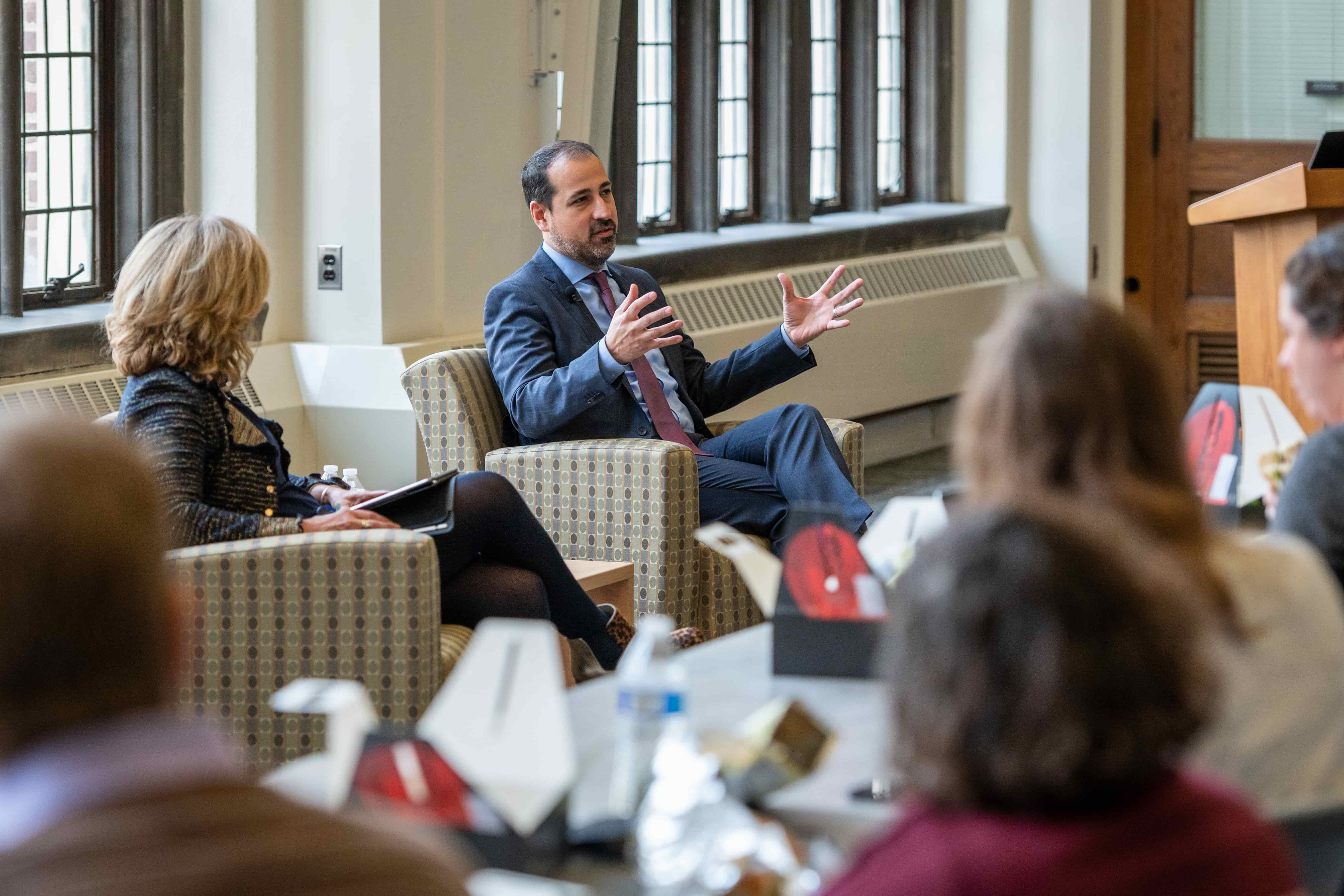 Roberto Rodriguez gestures while talking with Elizabeth Moje in front of an audience.