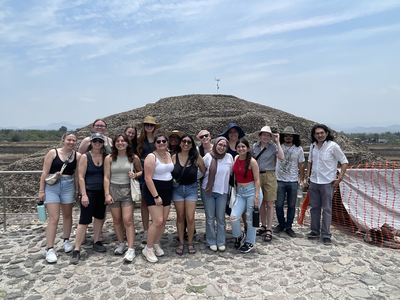 The whole ELD intern group stands in front of the rock pyramids of Teotihuacan.