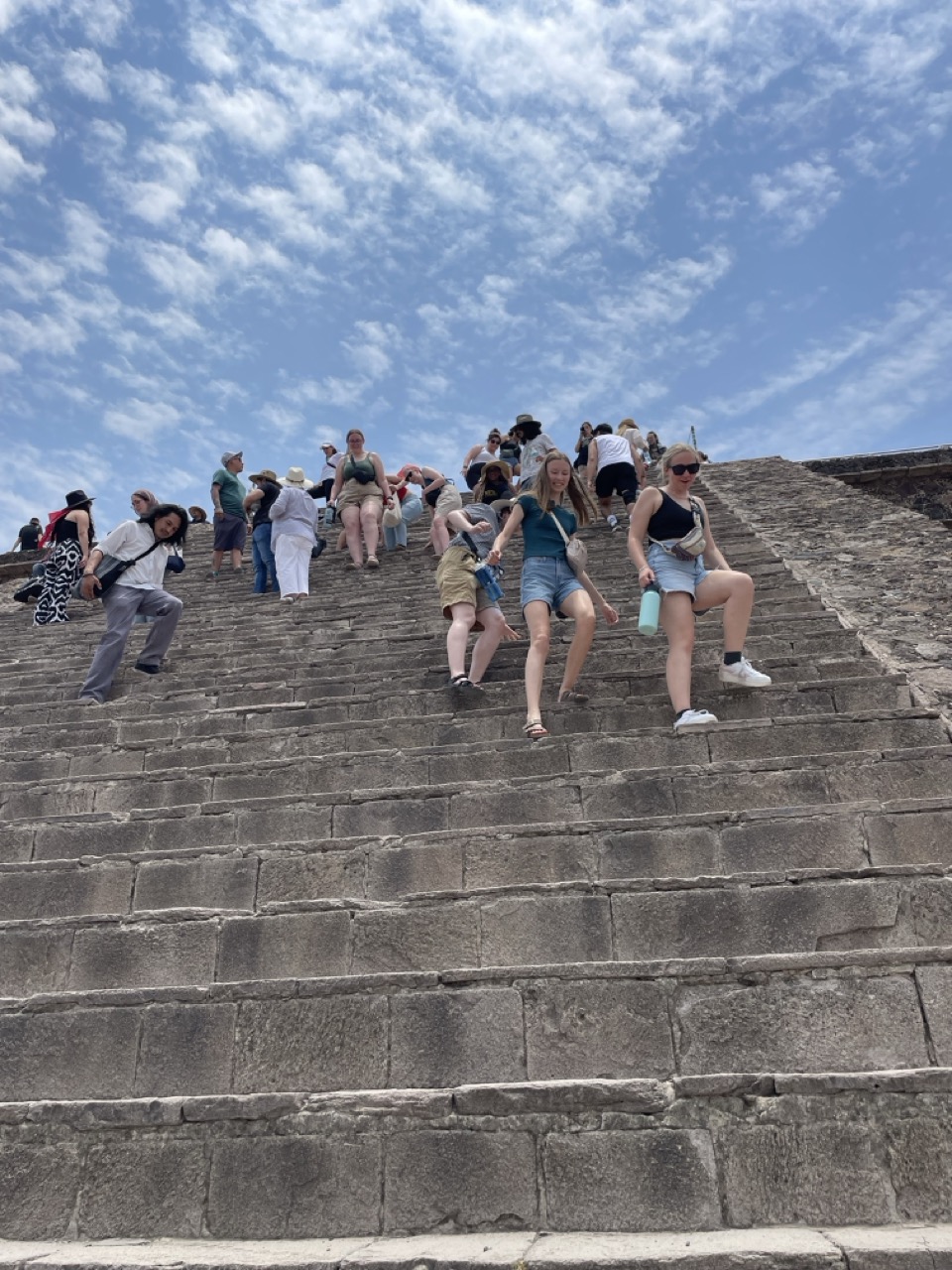 Three interns walk gingerly down the steep stone steps of a pyramid at Teotichuacan.