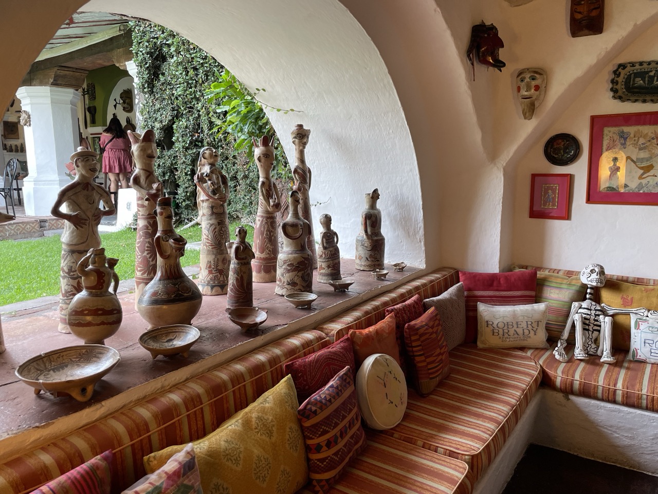 Clay artifacts and pots stand in an arch-shaped window at the Robert Brady Museum in Cuernavaca, Mexico.