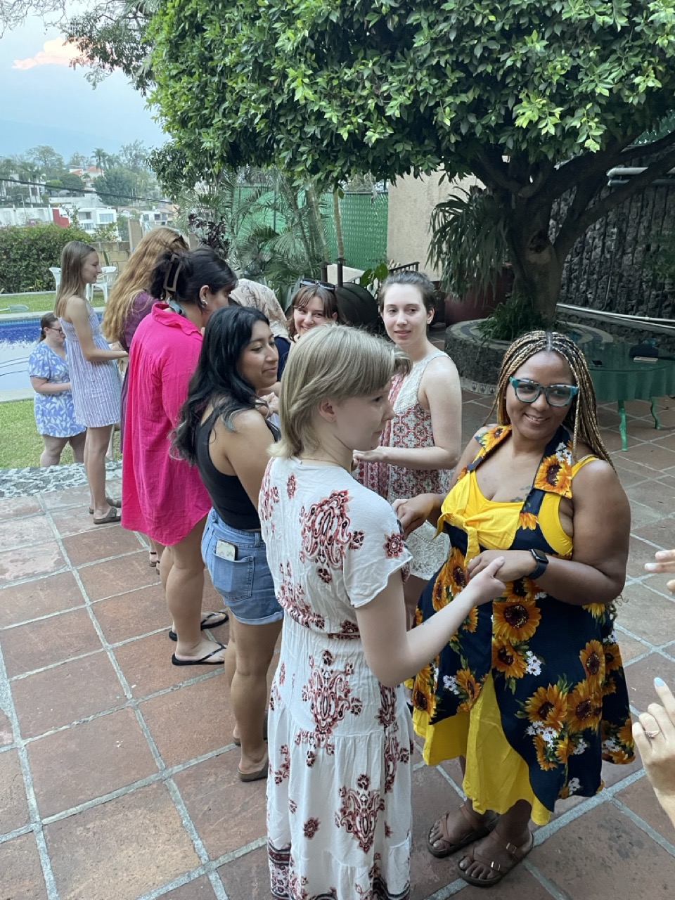 ELD interns stand in two lines, facing one another as they participate in a salsa dancing class outdoors.