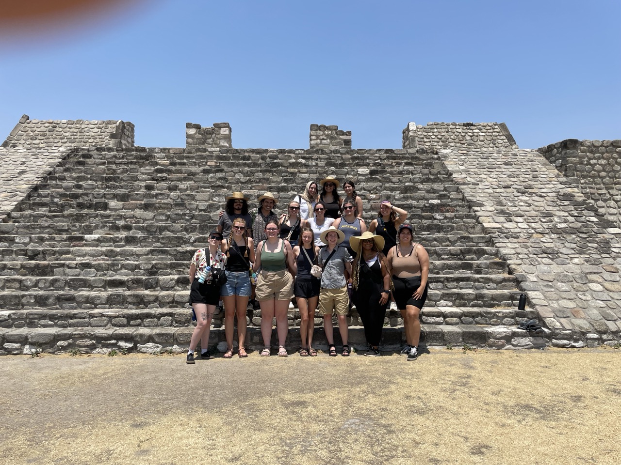 The whole ELD intern group stands in front of the rock pyramids of Xochicalco archaeological park.