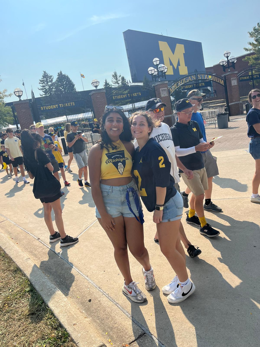 Two LEAPS students in Michigan gear pose outside the gates at Michigan Stadium