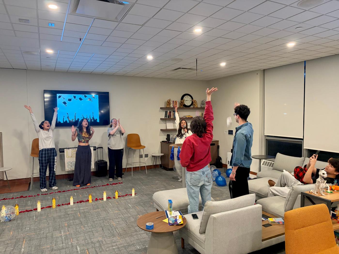 Students play some kind of game where multiple people have their hands raised and other students cheer them on.