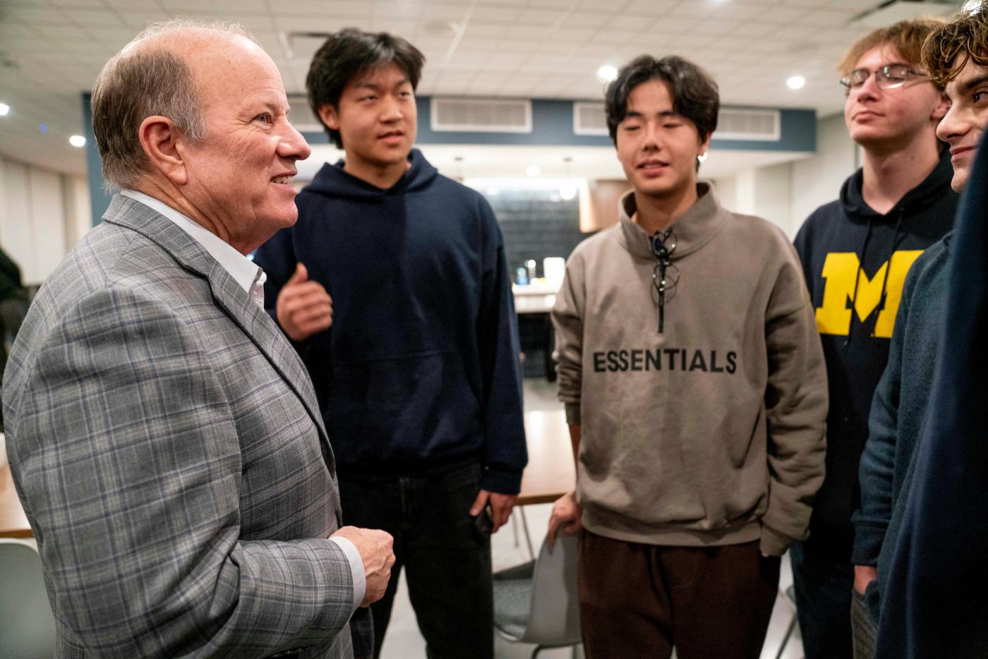 Four male students speak to former Detroit mayor Mike Duggan 