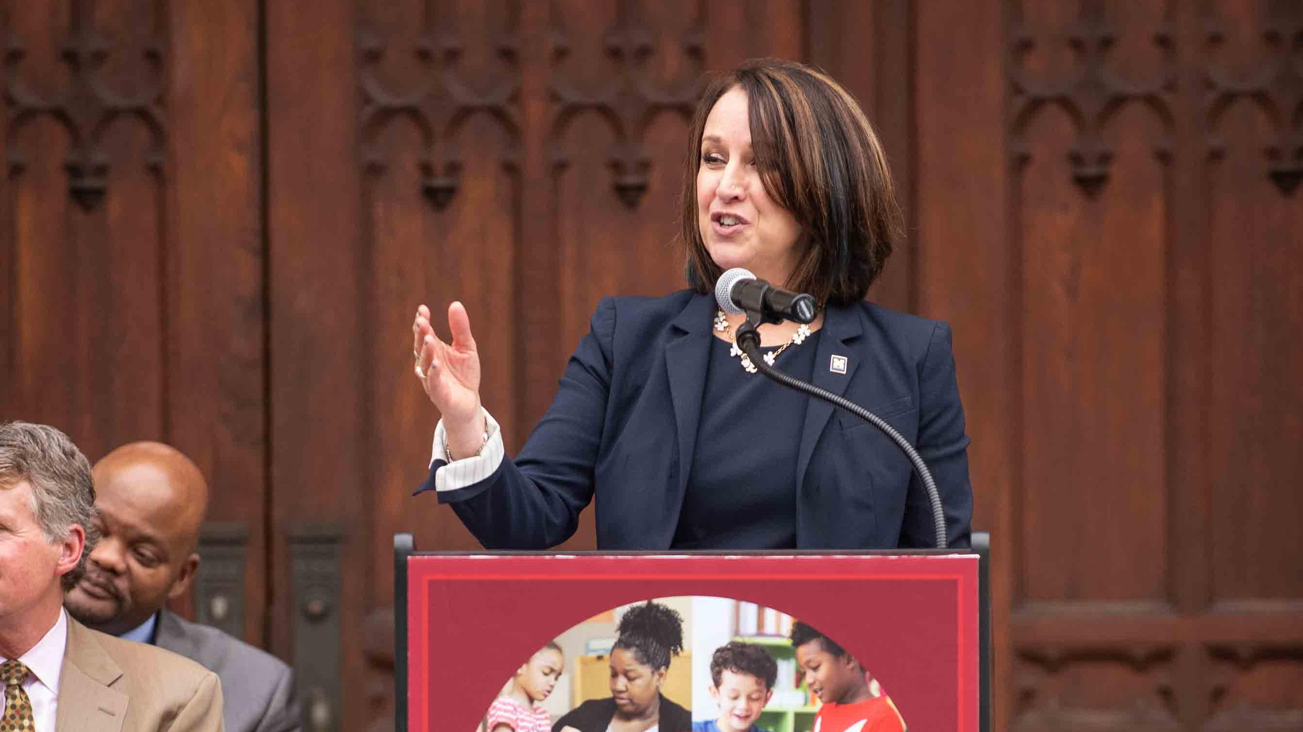 Elizabeth Moje, dean of the Marsal School, stands at a lectern and gestures toward the audience as she gives remarks celebrating the launch of the Detroit P-20 Partnership in 2018.