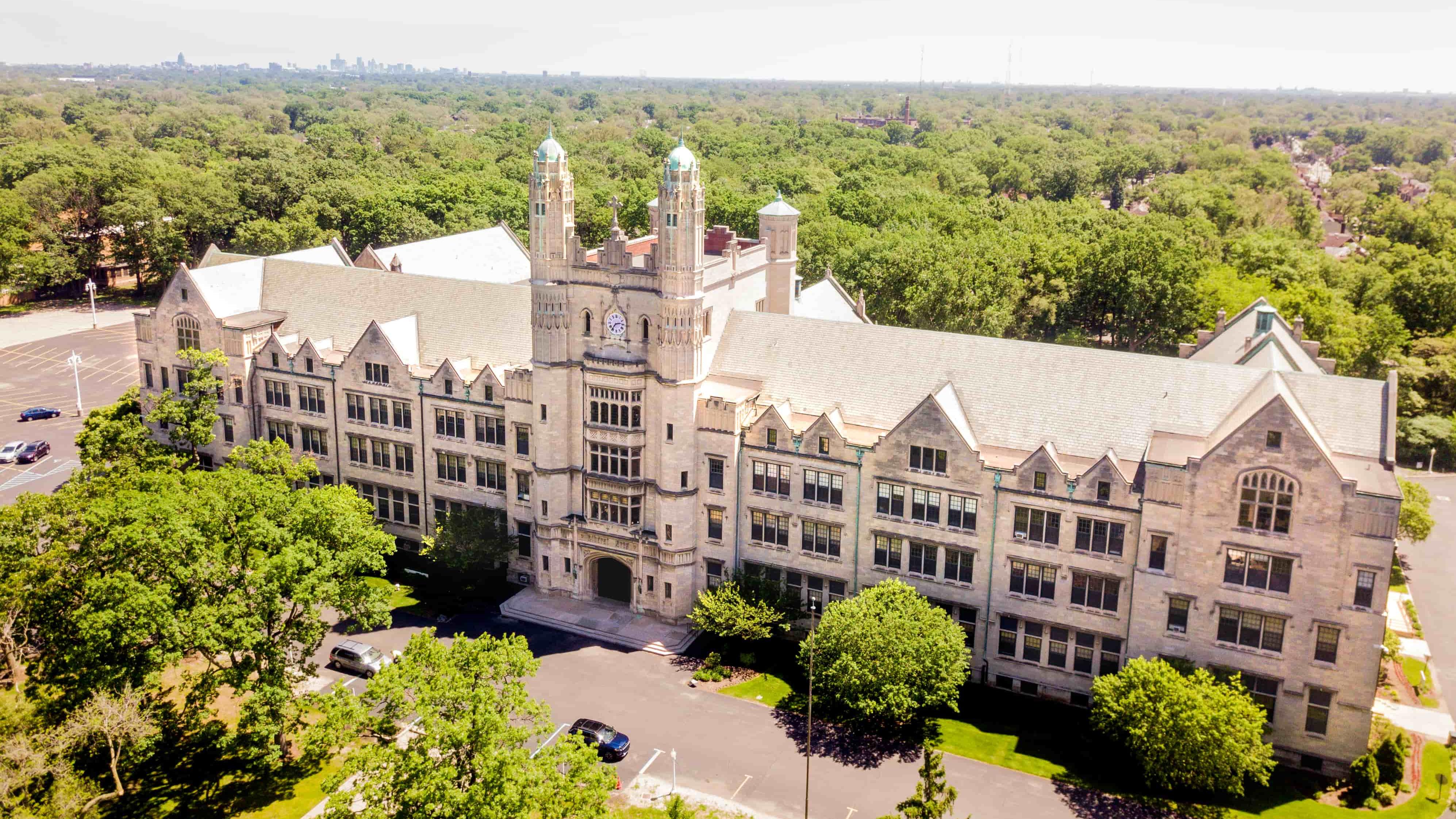 Drone photo of the former Liberal Arts Building, which now houses the middle and high school. Its beautiful neo-gothic architecture stands out, surrounded by greenery.