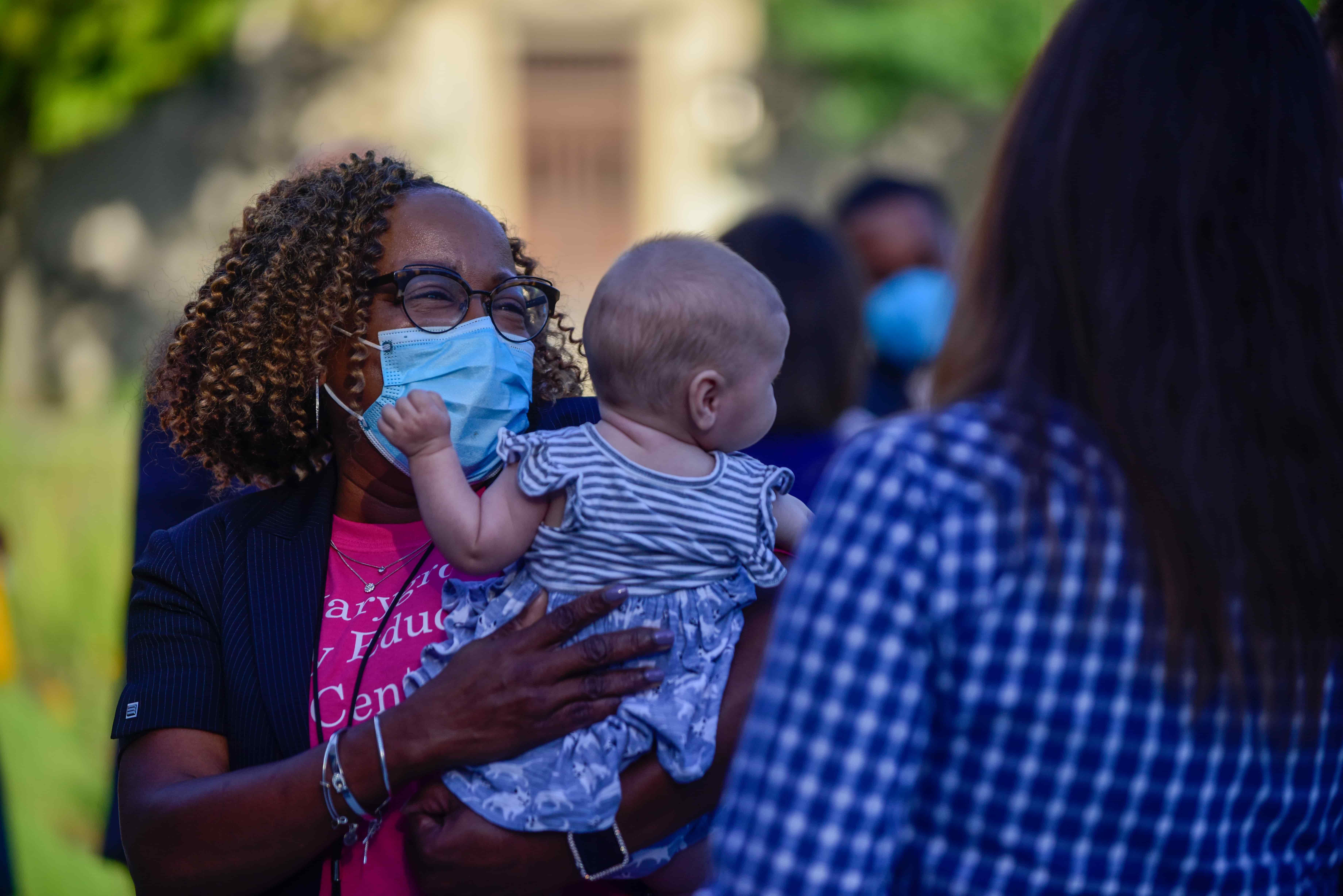 An administrator at the Marygrove Early Education Center holds a baby of approximately one year old.