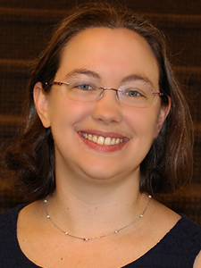 Headshot of smiling adult wearing glasses.