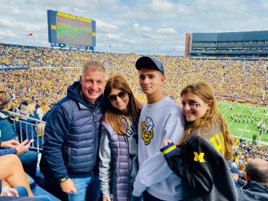 Photo of the Feinberg family in Michigan Stadium during a football game.