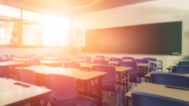 the sun shining through windows of an empty classroom