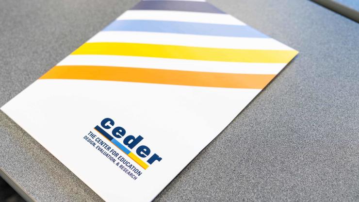 CEDER-branded folder on a grey desk