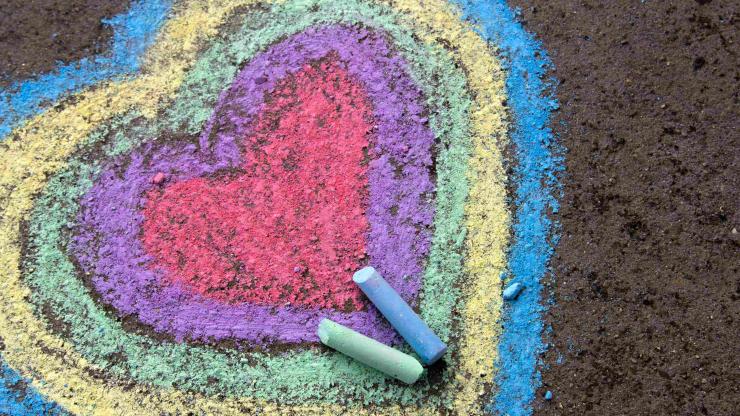 Concentric hearts drawn on sidewalk with red, purple, green, yellow, and blue chalk