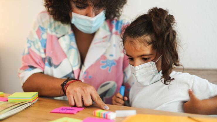 Preschooler with teacher wearing masks