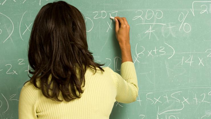 Young woman doing math on board