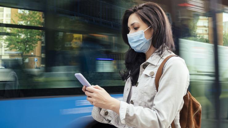 woman checking phone with mask on