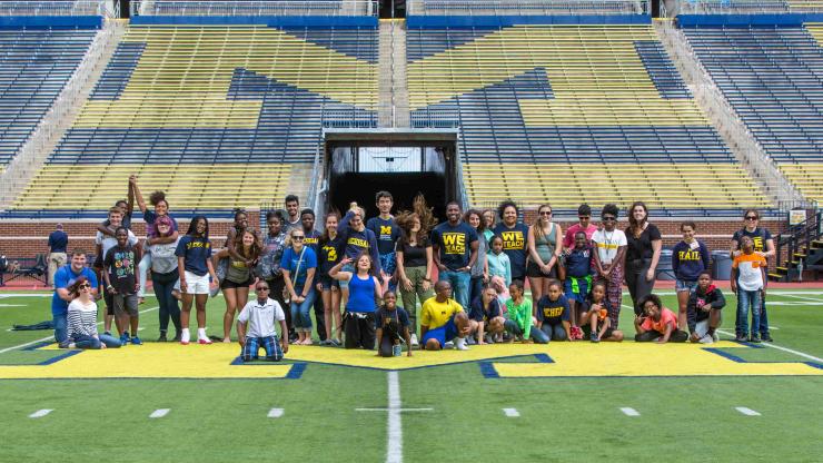 TeachingWorks team members and students pose for a photo inside Michigan Stadium