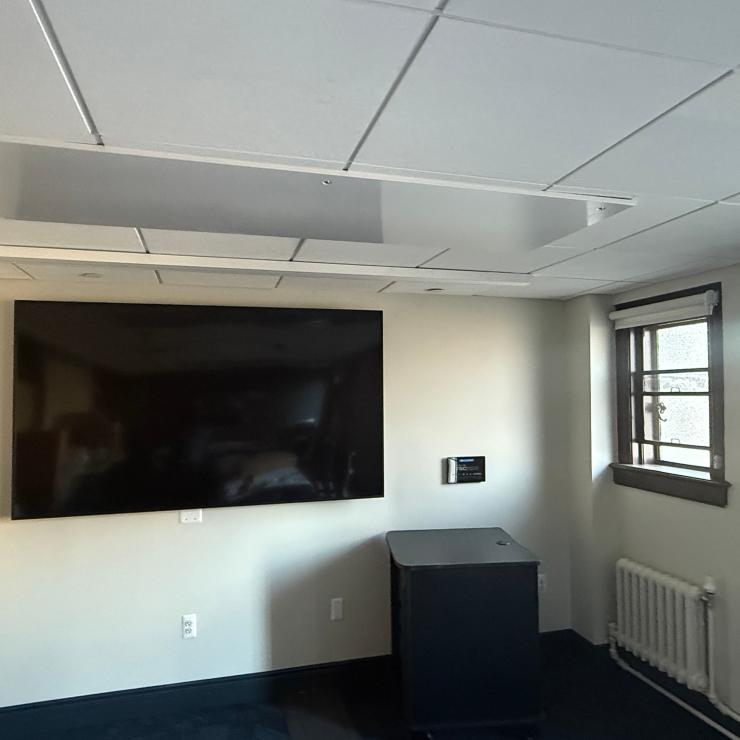 Image of conference room, with monitor on the far wall