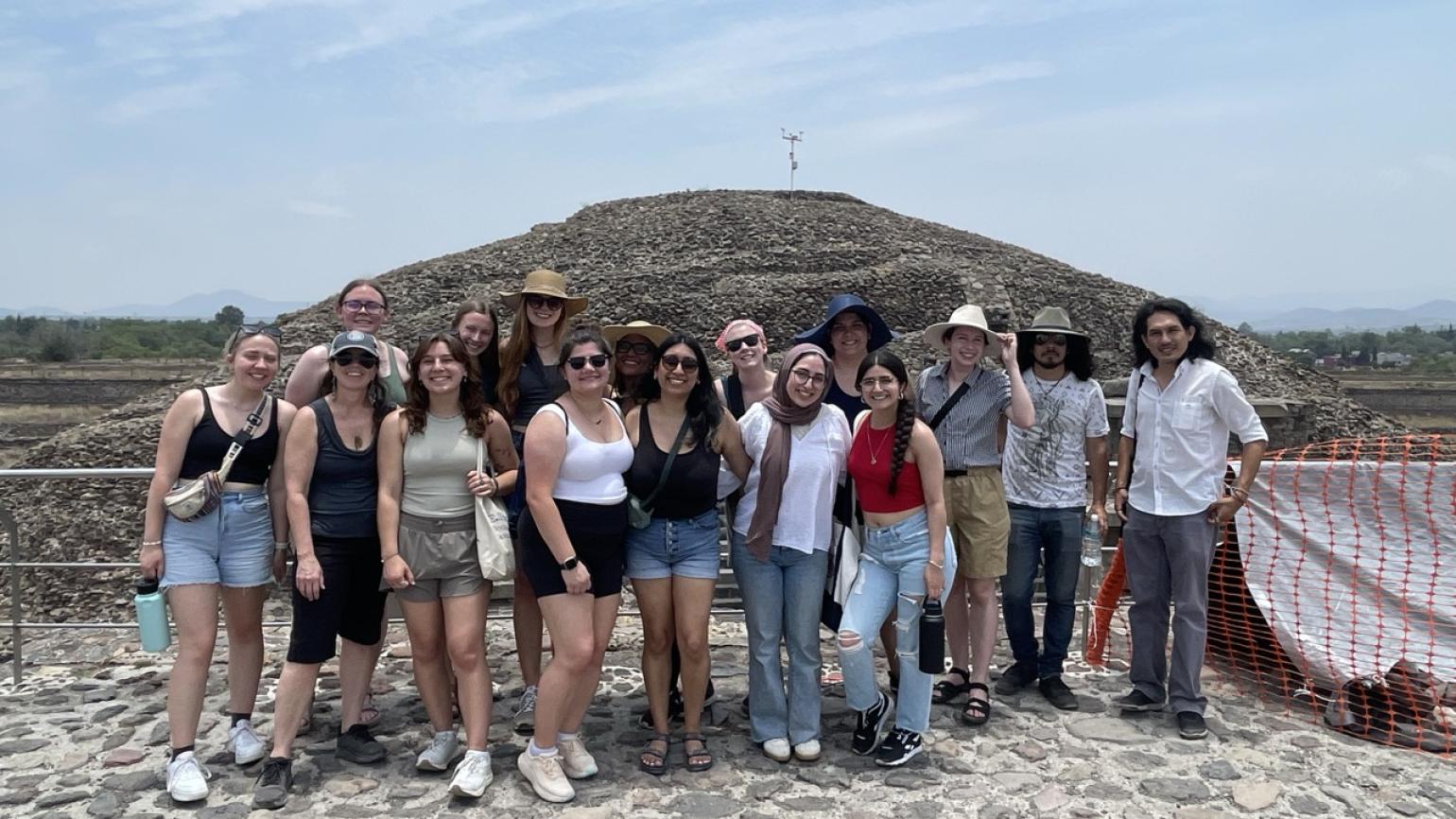 The whole ELD intern group stands in front of the rock pyramids of Teotihuacan.