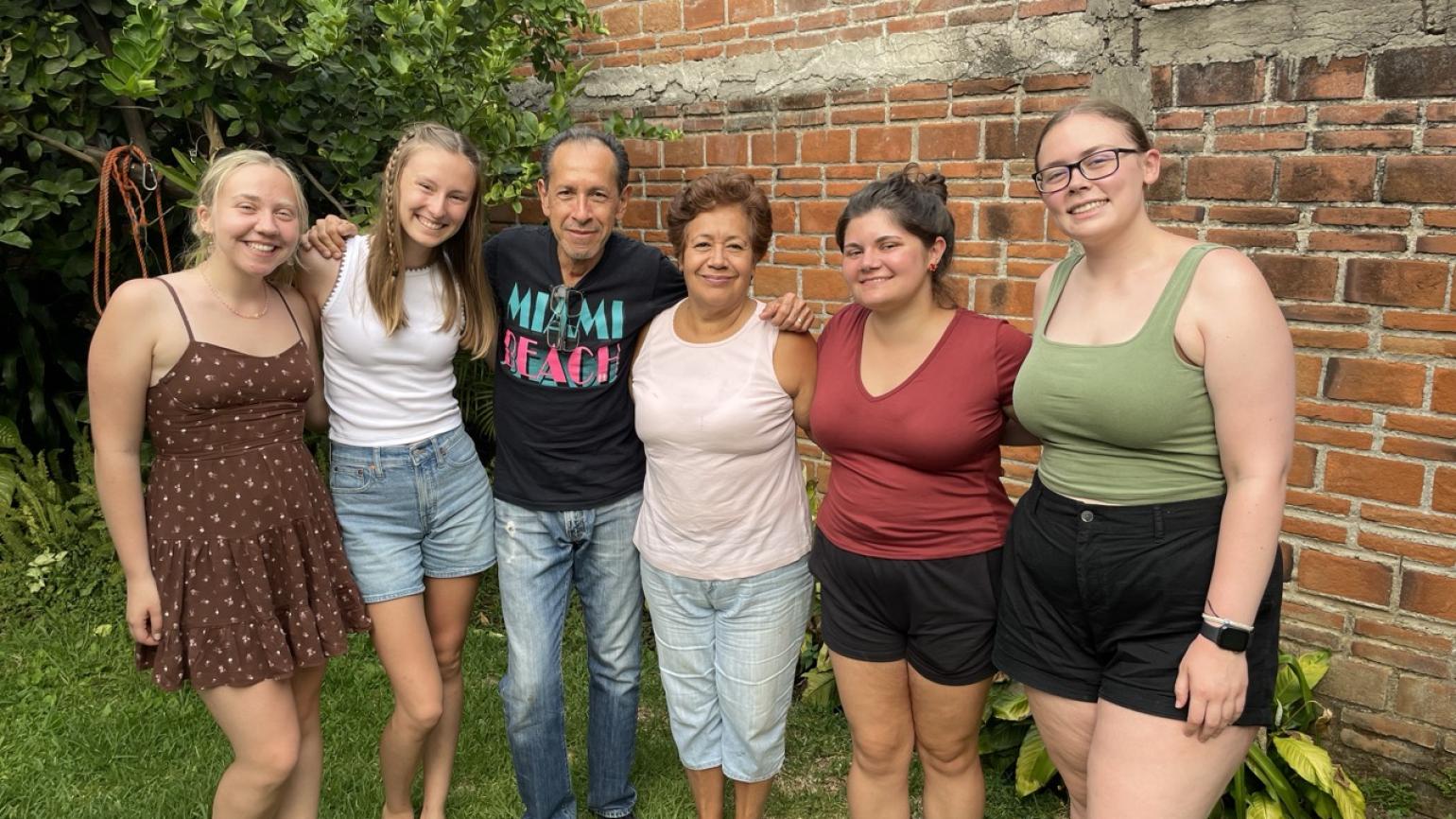 Teaching interns pose for a photo with their host family