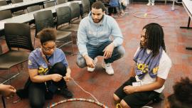 Teacher meeting with students in a circle.