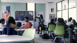 Video still from Marygrove Learning Community video showing teacher in front of classroom 