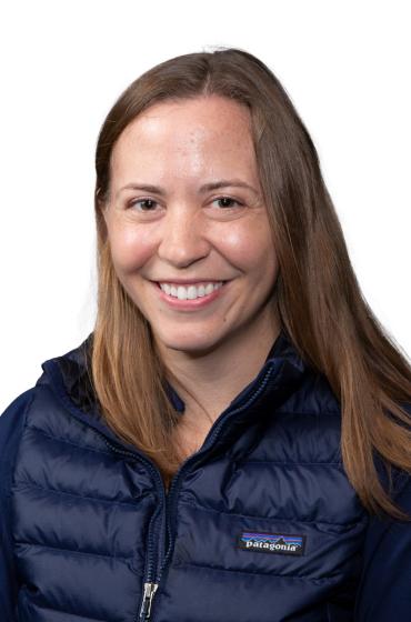 Image of smiling woman with shoulder length brown hair, wearing a black jacket