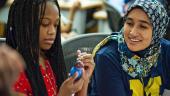 Teaching intern watches as student colors a replica of a heart