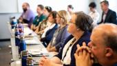 Attendees pay attention to seminar speaker off camera