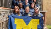 The whole ELD intern group gathers on stairs and poses in front of the block M flag on our last day of class. Everyone is wearing their U of M ELD abroad blue t-shirt.