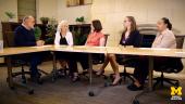 Don Peurach, Deborah Ball, Francesca Forzani, Nicole Garcia, and Kyana Taylor sit around a conference table having a discussion, with plants and a fireplace visible in the background.