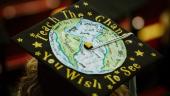 A graduate mortarboard with a hand-drawn depiction of the globe surrounded by the words "Teach the change you wish to see."