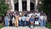 A group of smiling students standing in front of the school of education building