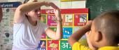 Teacher in classroom makes shapes with her hands